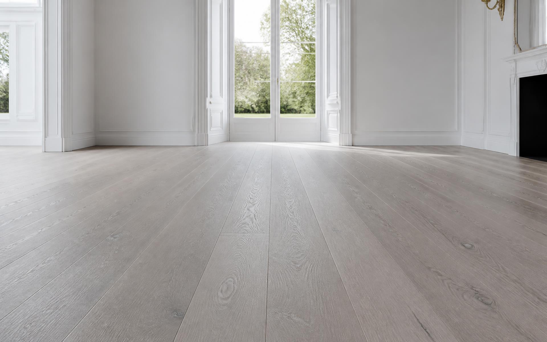 Wide-plank pale oak floor photographed at floor level with raking daylight across the boards