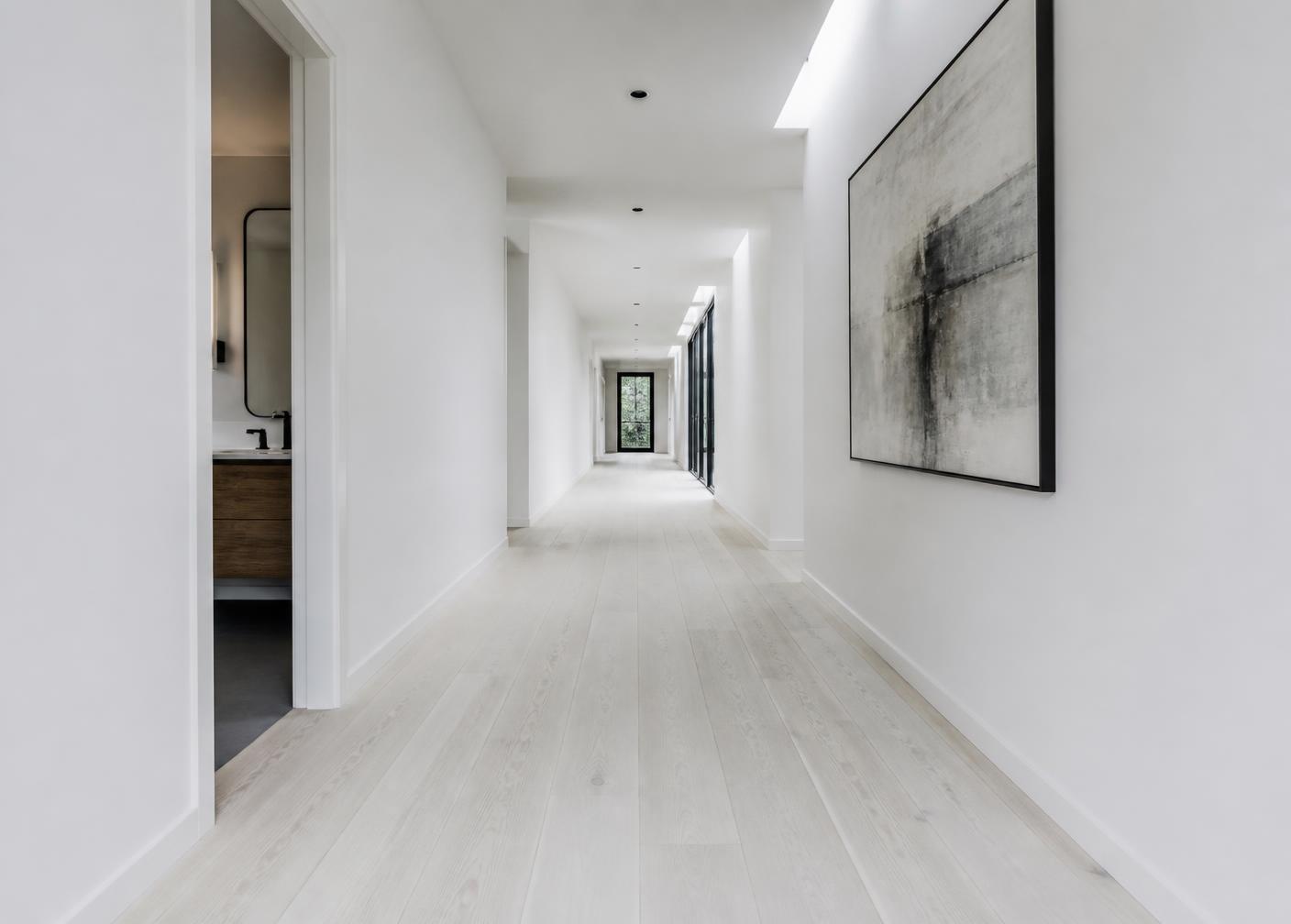 Corridor with pale oak plank flooring and daylight across the boards